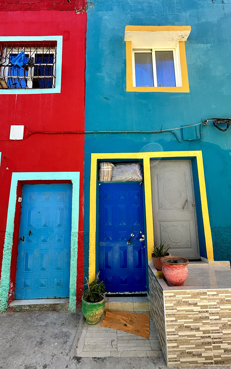 Aghroud village featuring vibrant rainbow-colored houses along the Atlantic coast in Morocco.
