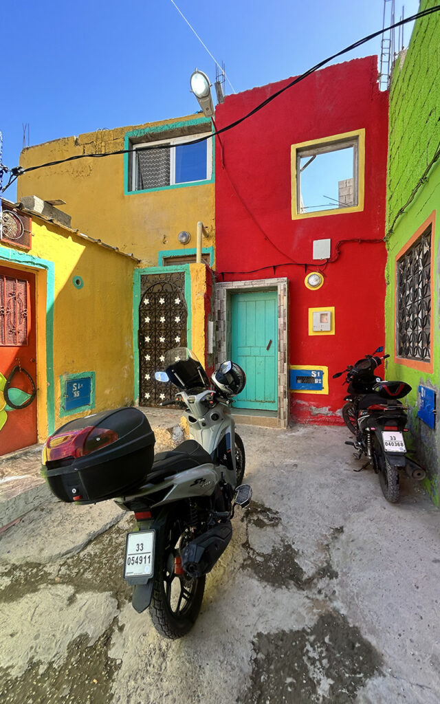 Brightly painted residential houses on a hillside in the colorful village of Aghroud.