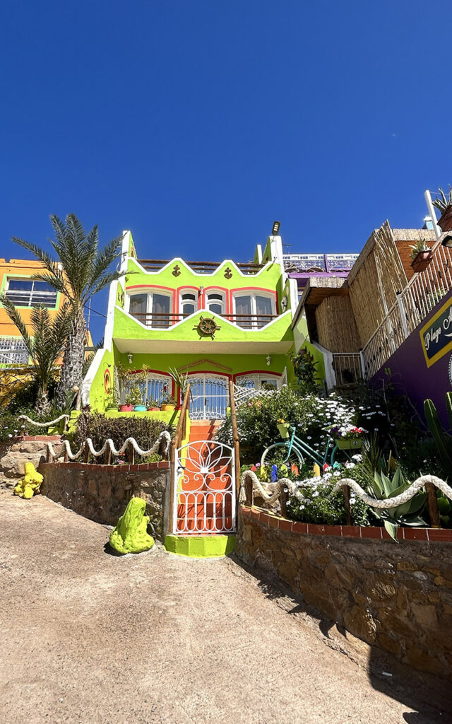 Vibrant street scene in Aghroud with multicolored facades and blue sky background.