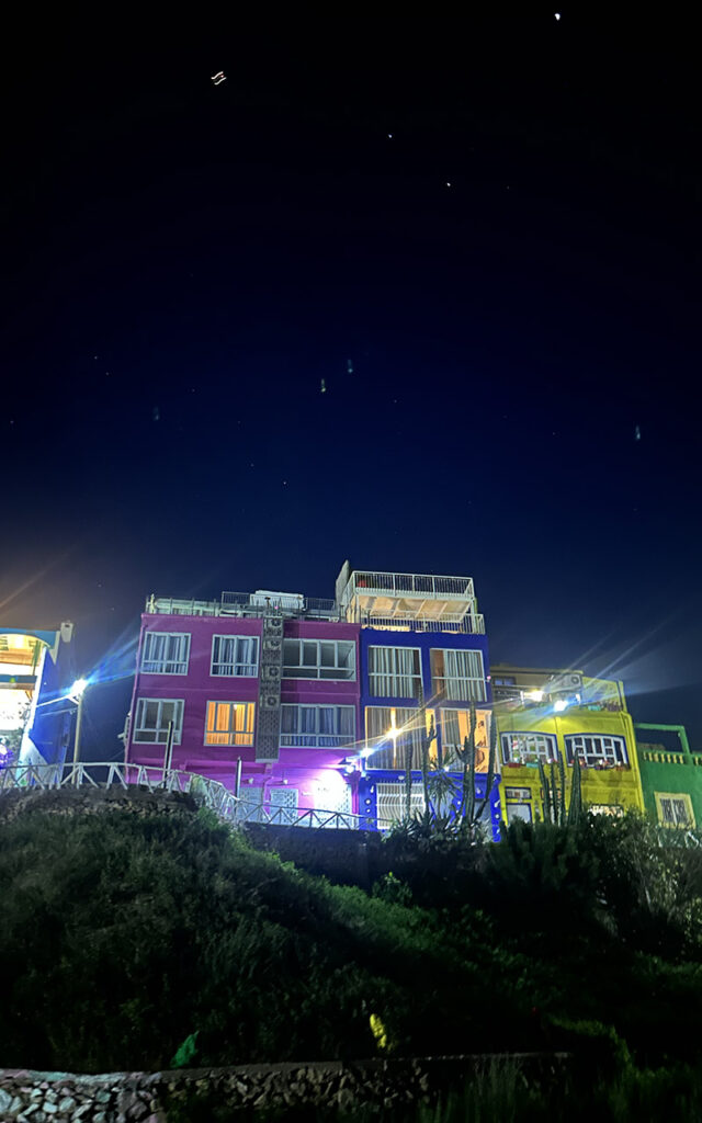 Brightly painted residential houses on a hillside in the colorful village of Aghroud.