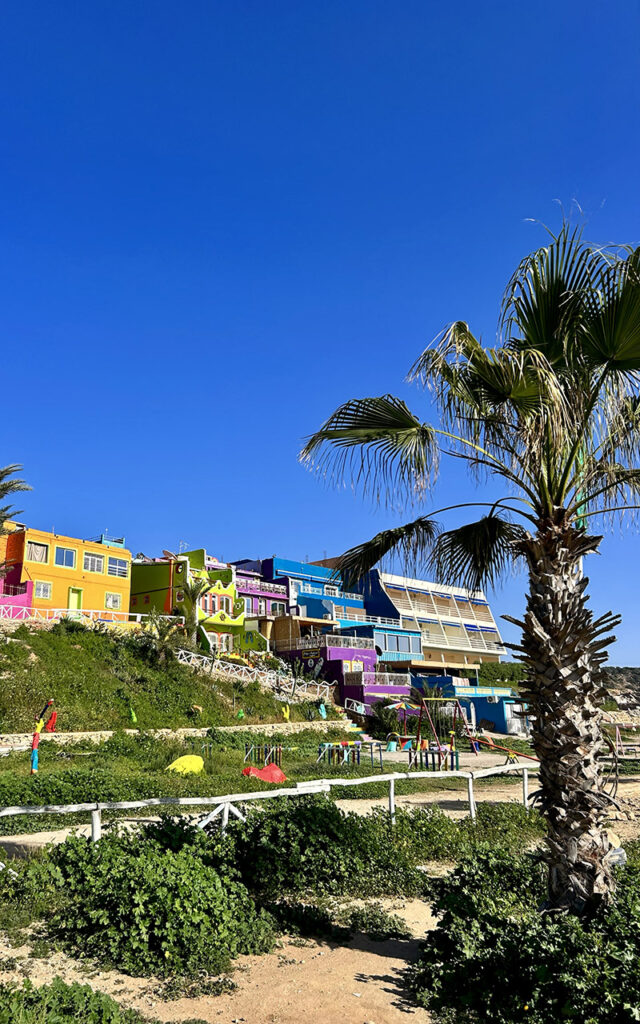 Aghroud's unique colorful architecture and coastal scenery on a sunny day in Morocco.