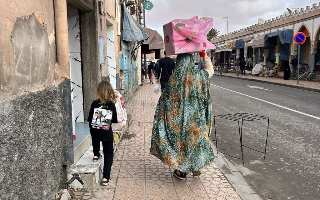 Lady in Morocco walking with box on her head.
