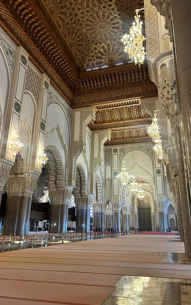 Main prayer hall inside Hassan II Mosque in Casablanca with chandeliers and detailed architecture