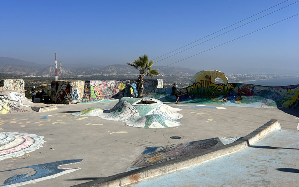 Taghazout skatepark during daytime with colorful graffiti murals and bay view, Morocco