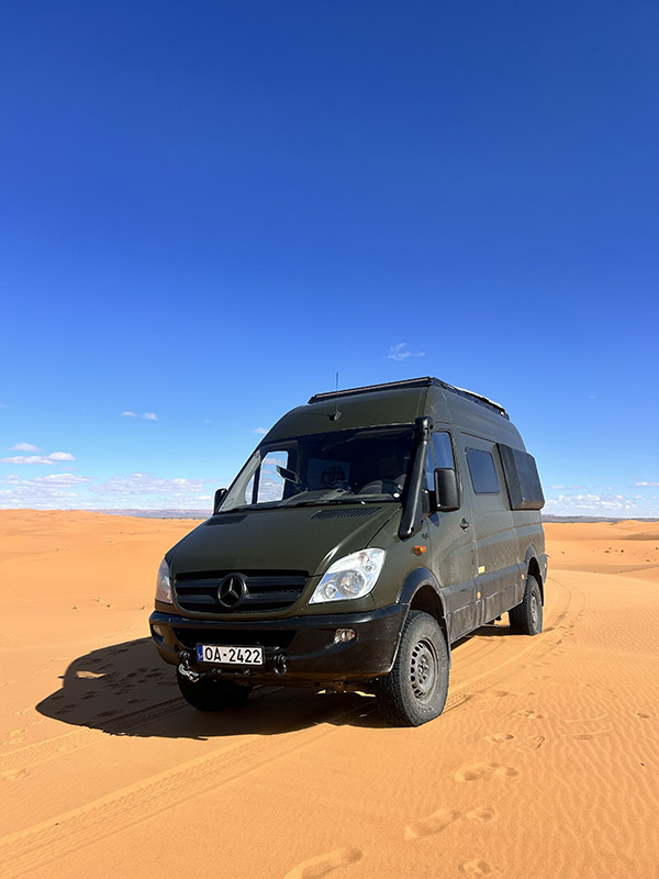 A green Sprinter camper van on an epic adventure in the Moroccan desert dunes